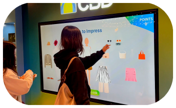 People playing a multi-level interactive financial literacy game at a brand activation event in Dubai, learning how to save and invest money.